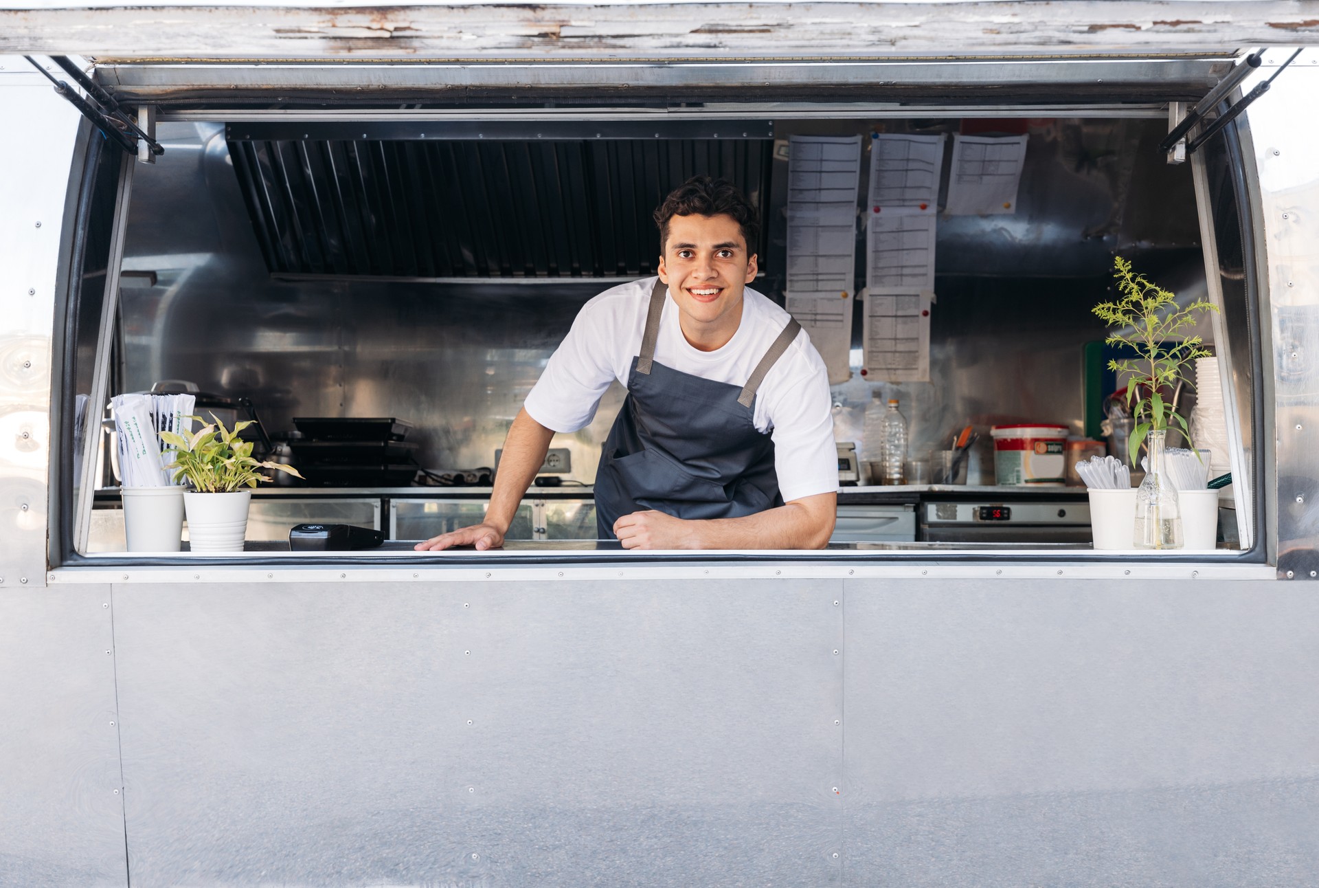 Portrait of a young food truck owner. Food truck owner waiting for customers.