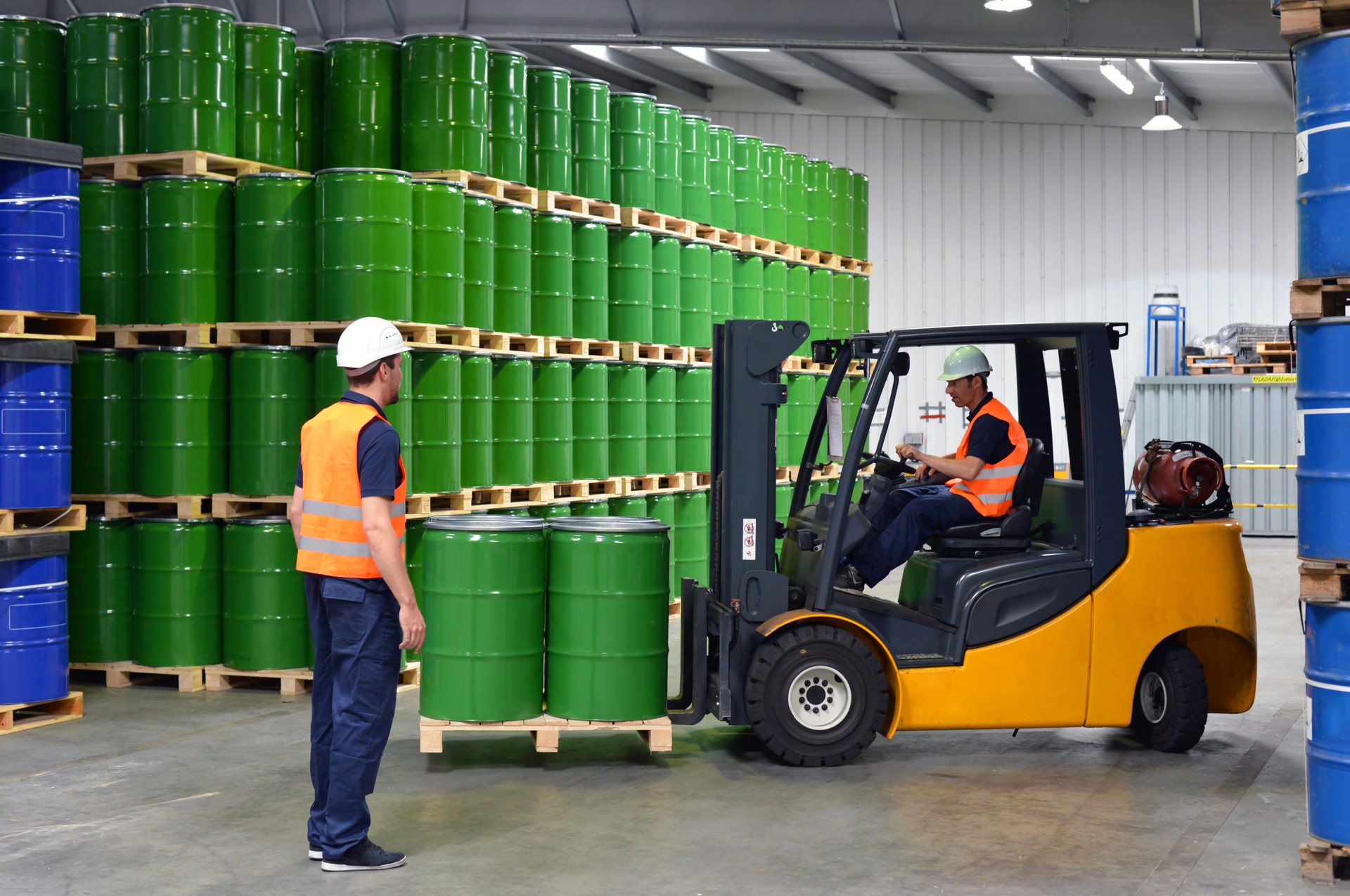 group of workers in the logistics industry work in a warehouse with chemicals