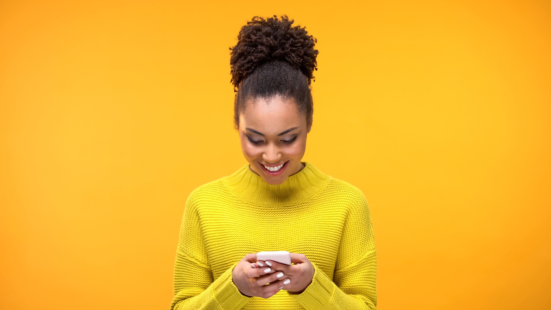 Smiling African-American woman chatting on smartphone, modern technology, app